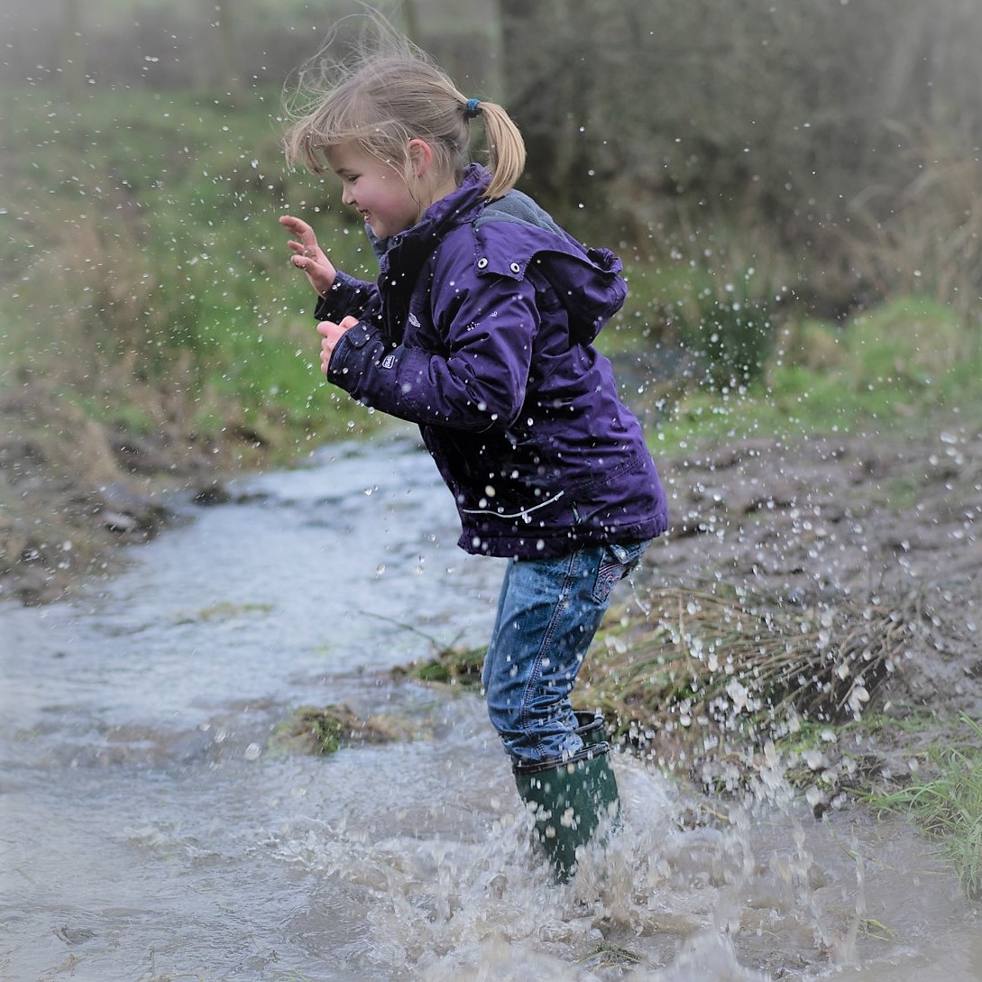 girl jumping in puddles